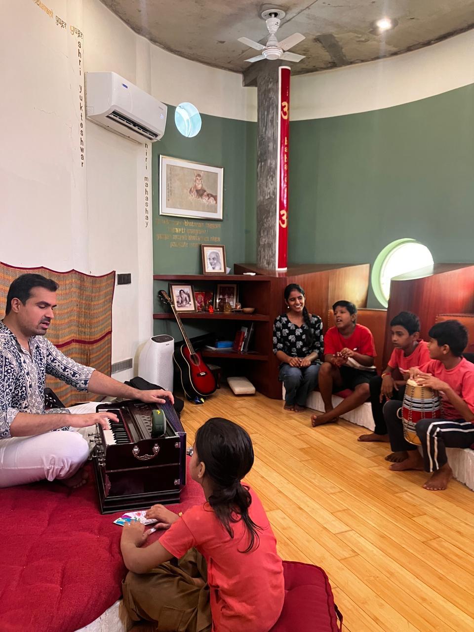 Priyal leading a small bhajan-learning circle with children